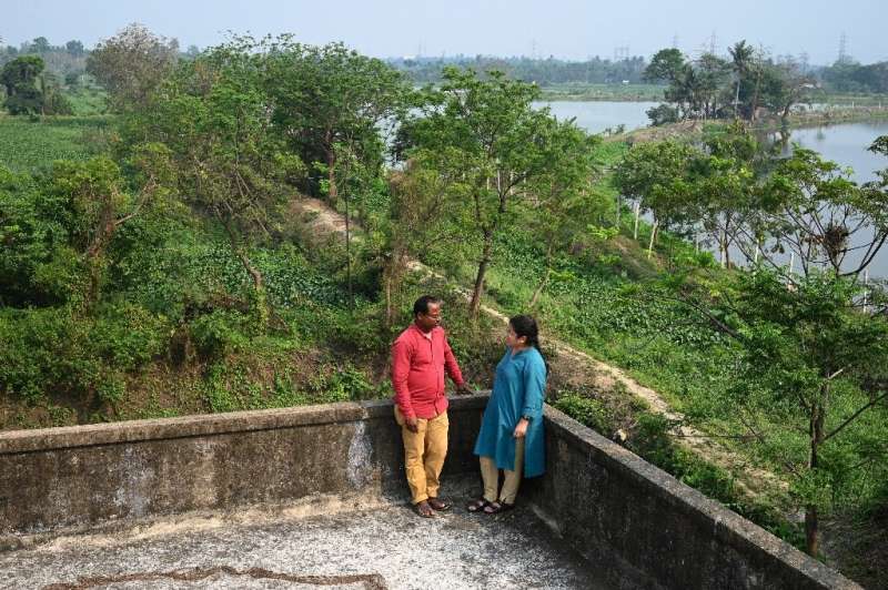 Environmental researcher Dhruba Das Gupta talks to fish farmer Sujit Mondal, who says pollution is hurting production