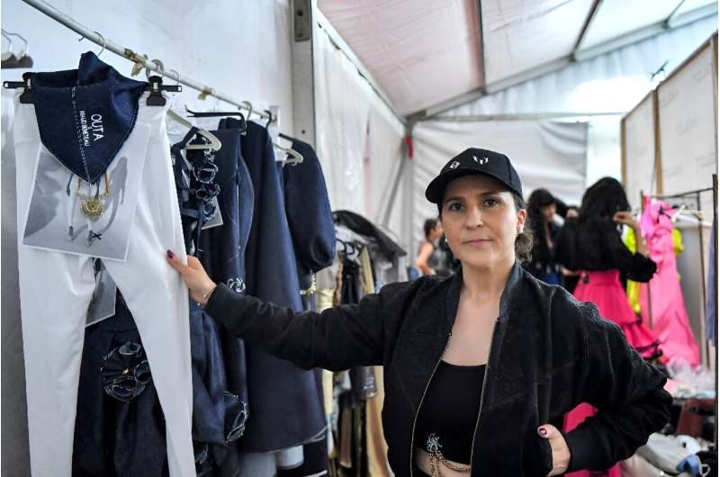 French fashion designer Maud Beneteau poses for a photograph with her designs backstage during a fashion show at Tunisia's Carth