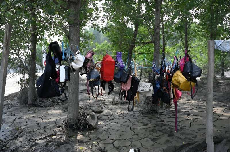 Handbags are hung to dry by a muddy street in the aftermath of flooding after heavy rains in Zhuozhou city, in northern China's 