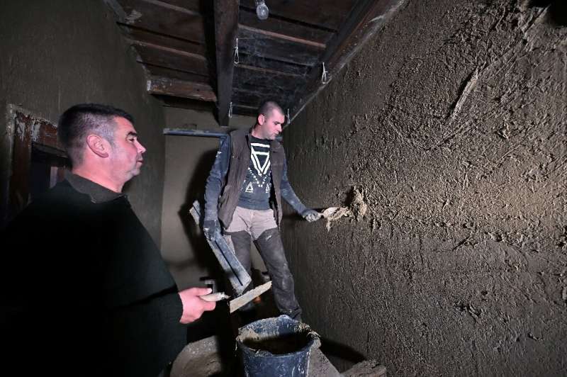 Master builder Janos Gaspar (L) oversees mud plastering