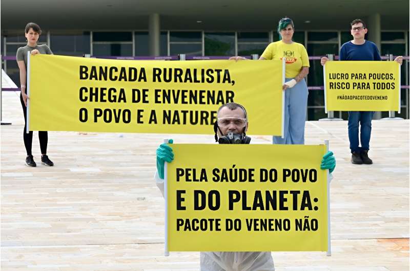 Members of an environmental group protest in front of the National Congress in Brasilia against the new pesticide law that eases the trade and use of these products, on October 4, 2023