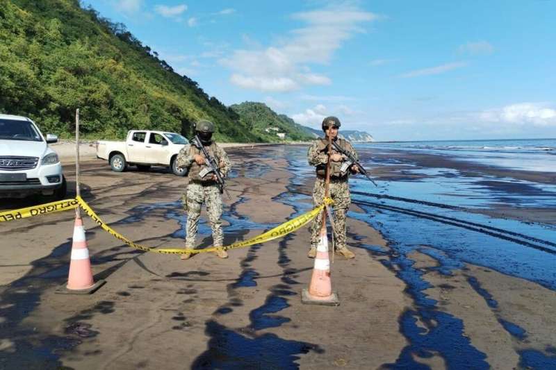 Members of the Ecuadoran Armed Forces stand guard on the shore of a beach covered with oil after a leak in Esmeraldas province o