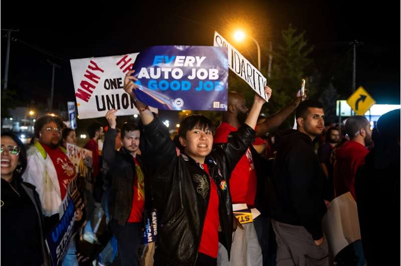 Members of the UAW (United Auto Workers) picket and hold signs outside of the UAW Local 900 headquarters across the street from the Ford Assembly Plant in Wayne, Michigan on September 15, 2023