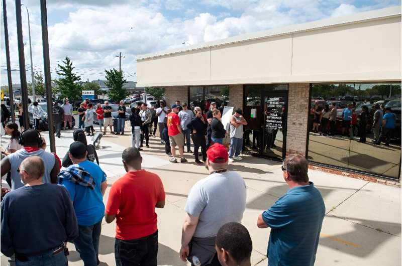 Members of the United Auto Workers (UAW) line up outside of the UAW Local 900 headquarters to sign up for strike funds