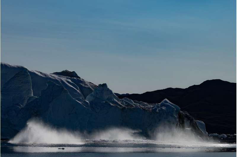 Parts of a melting iceberg collapses into the sea in Greenland's Scoresby Sound