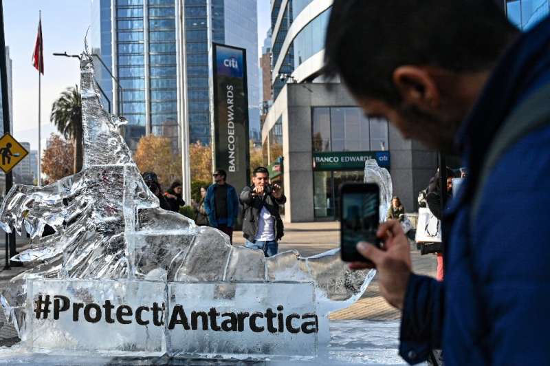 Passers-by take photos of an ice sculpture representing a krill in Santiago on June 19, 2023 as the Commission for the Conservat