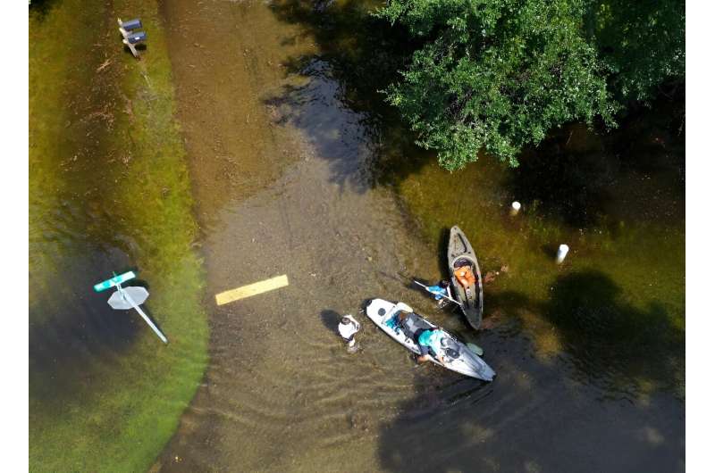 People prepare to kayak through the flooded streets of Crystal River, Florida, amid flooding caused by Hurricane Idalia
