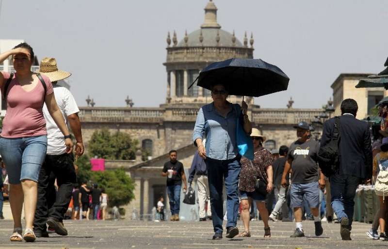 People try to protect themselves from the sun in Guadalajara, Mexico, on June 12, 2023