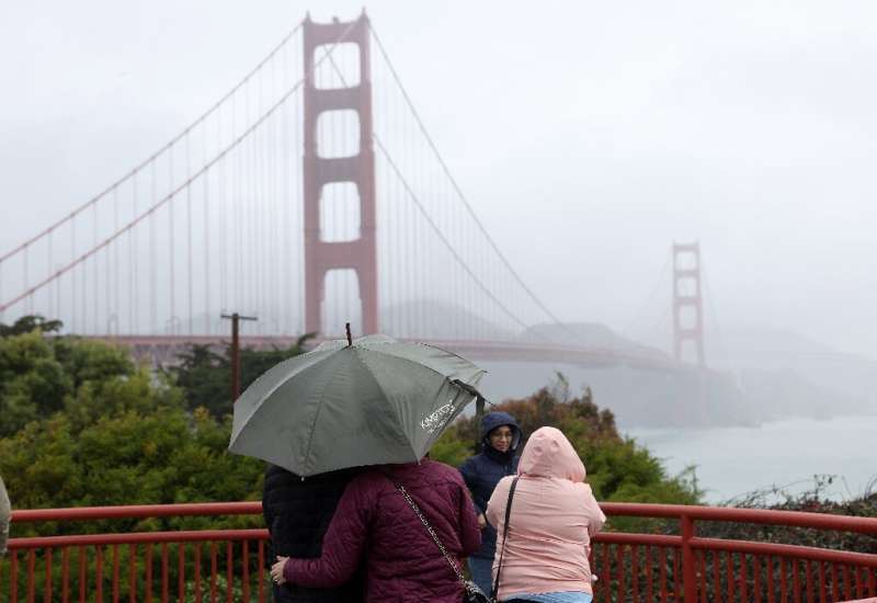 People visit the Golden Gate Bridge as a rain storm moves through the San Francisco area on January 04, 2023