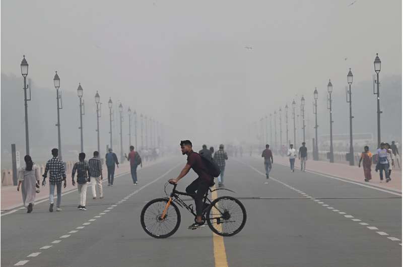 People walk along the Kartavya Path near India Gate amid heavy smog in New Delhi