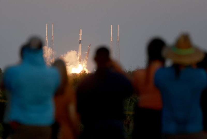 People watch as a SpaceX Falcon 9 rocket lifts off at Cape Canaveral Space Force Station on February 27, 2023