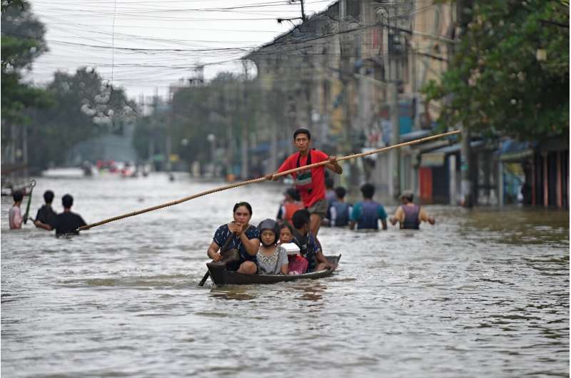 Residents waded down streets through waist-deep water or floated along in boats or on rubber tyres