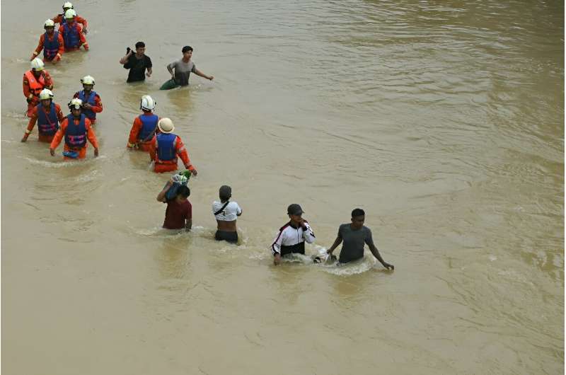 Residents walk through a flooded street after heavy rains in Myanmar's Bago township
