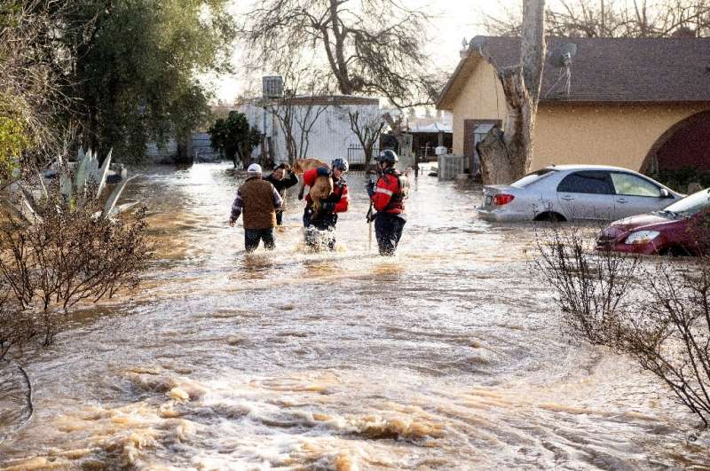 San Diego firefighters rescue dogs from a flooded home in Merced, California, on January 10, 2023 as a relentless series of stor