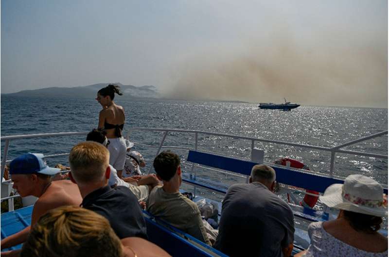 Smoke from fires were part of the scenery for tourists on a ferry to Greece's Corfu island