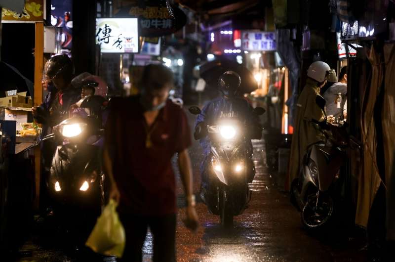 Some braved the downpour in Yilan county to shop at a nighttime market that had remained open despite the authorities' warning o