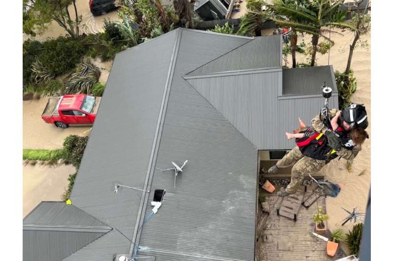 Stranded people are airlifted from their rooftop by a military helicopter near the North Island city of Napier