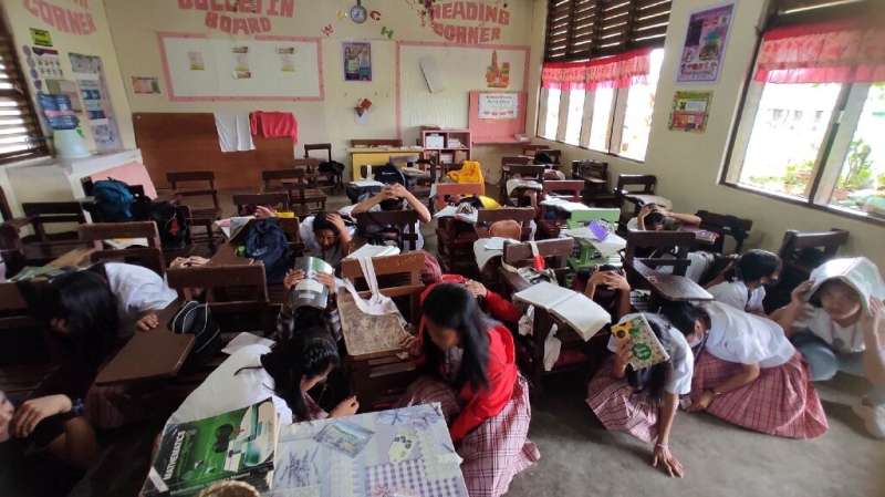 Students at the Buso National High School take shelter inside their classroom after a 6.0-magnitude earthquake jolted the southe