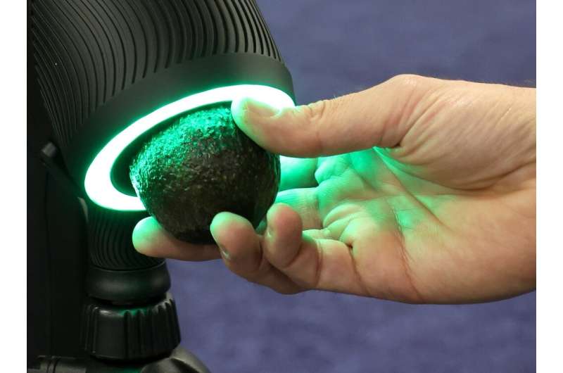 The OneThird Ripeness Checker is demonstrated checking an avocado during a press event at CES 2023