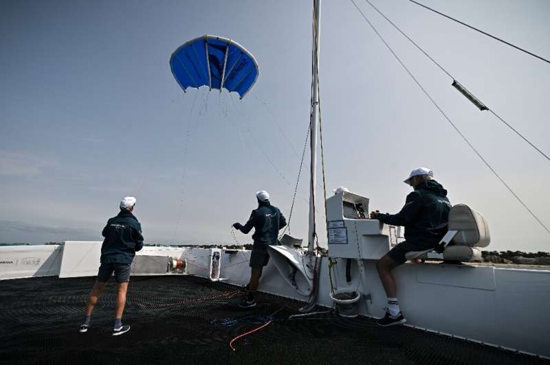 The startup Beyond The Sea tests a blue inflatable kite sail the size of a small studio to pull a specially-designed catamaran a
