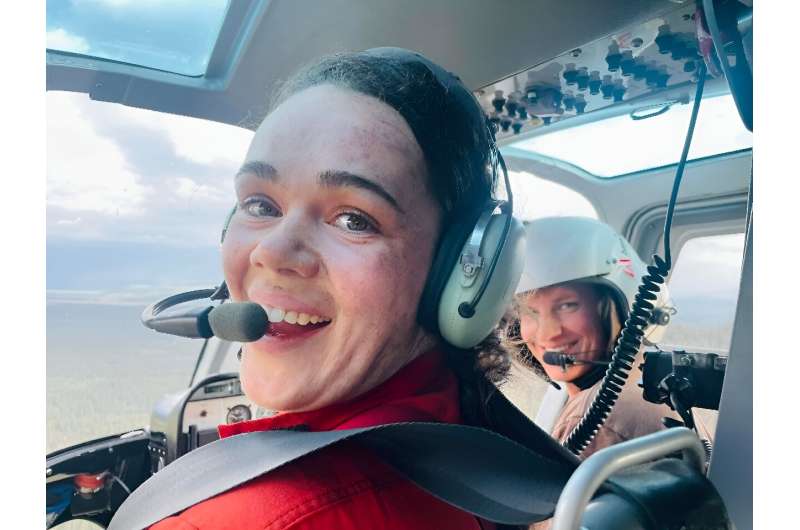 This handout photo dated July 13, 2022, shows firefighter Kara Galbraith (L), in a helicopter Carmacks, Yukon, Canada, flying to a fire. Galbraith was deployed with an Initial Attack Crew to help with the fires in the Yukon