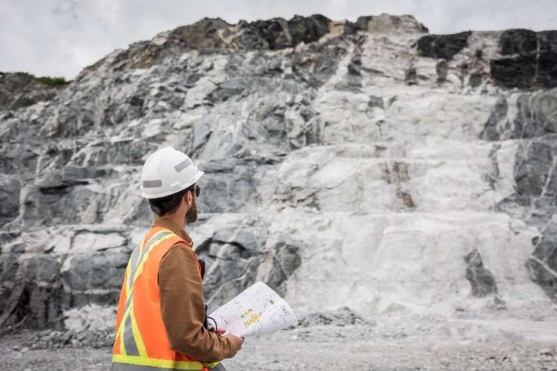 This handout picture provided by Sayona Quebec shows an employee in front of a lithium deposit at the company's lithium complex 