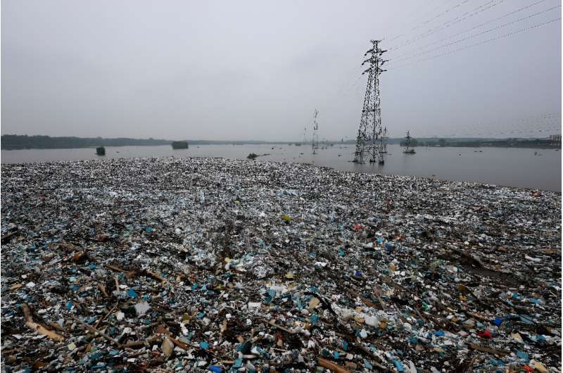 Vast piles of floating garbage and debris was backed up by a bridge