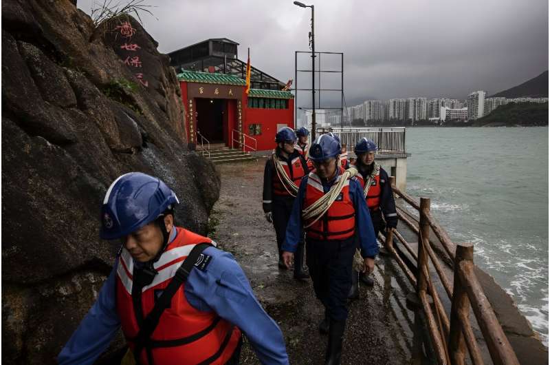 Volunteer workers evaluated the damage done to a low-lying fishing village after Typhoon Saola moved away from Hong Kong
