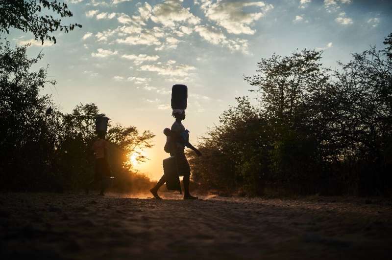 Women collect water from a communal tap several  hundred metres from their homes in Zimbabwe