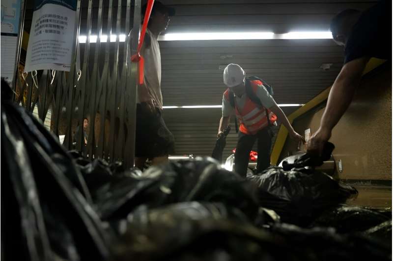 Workers clean up the mud at a subway station in Hong Kong