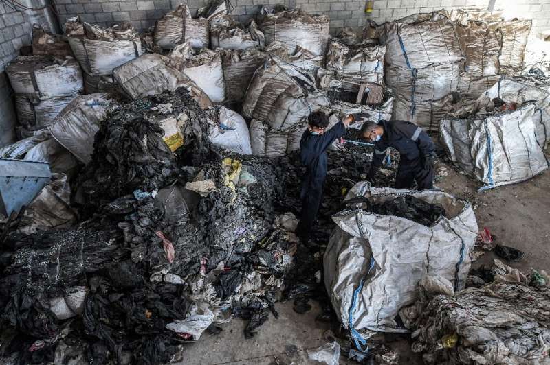 Workers sort through sacks of plastic waste at a workshop of the Egyptian startup company TileGreen