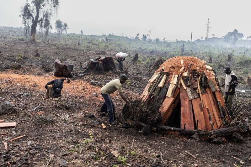 Youths tend a charcoal kin at the refugee camp in Kibati