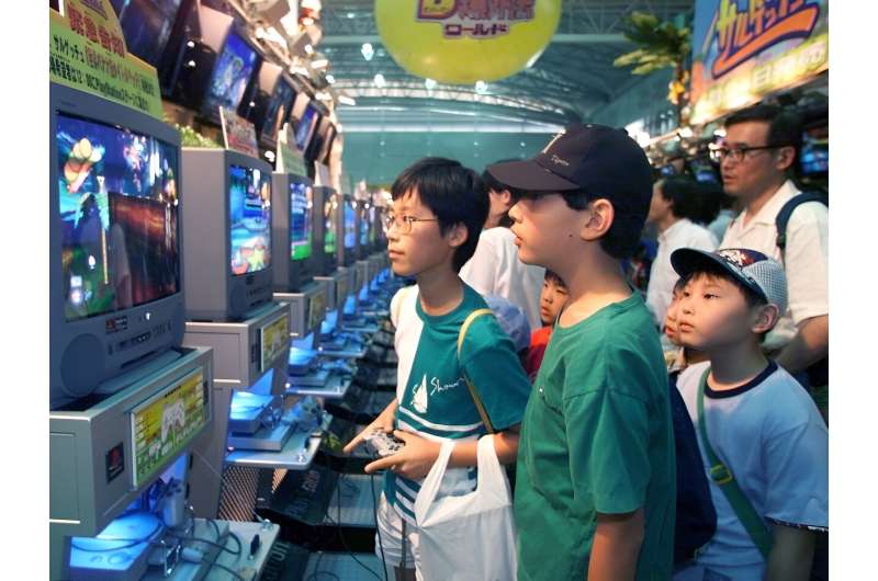 A boy tries out the new PlayStation video game console from Sony at the 10th anniversary of the new generation world hobby fair in Makuhari, Chiba Prefecture 12 June 1999