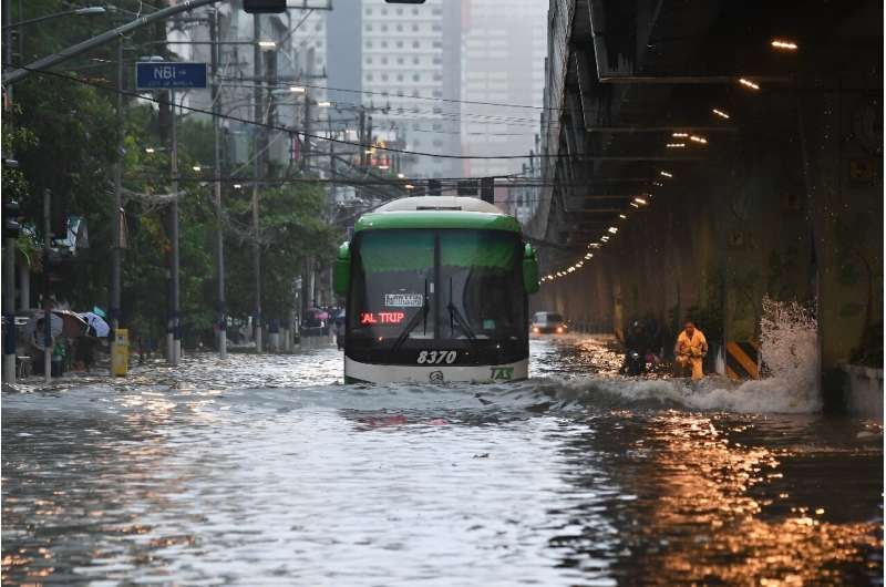 A bus ploughs through a flooded street in Manila