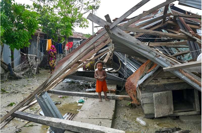 A child stands at his damaged house after a cyclone in low-lying Bangladesh