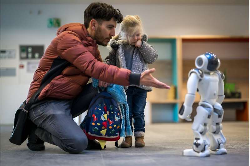 一位父亲在瑞士托儿所向他的女儿介绍一个名叫 Nao 的机器人