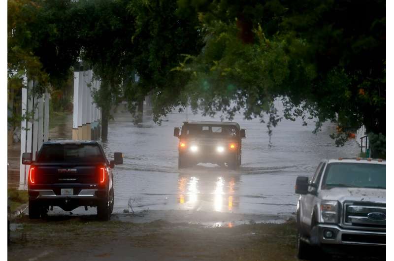 A Florida National Guard vehicle drives through a flooded street