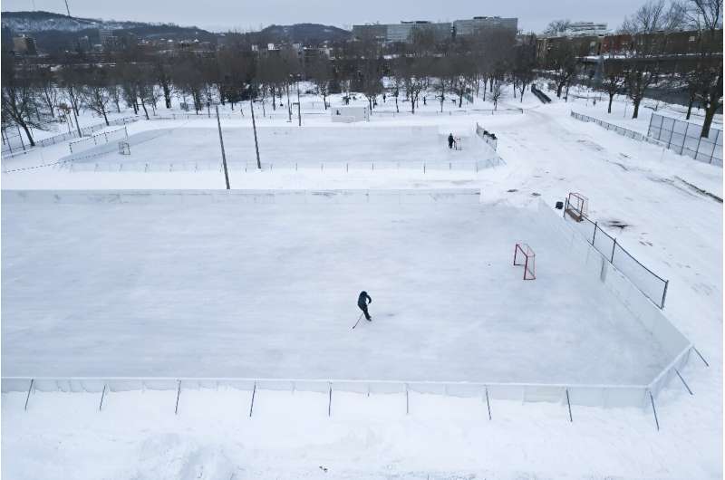A hockey player skates on one of the few open outdoor ice rinks at Laurier Park in Motnreal