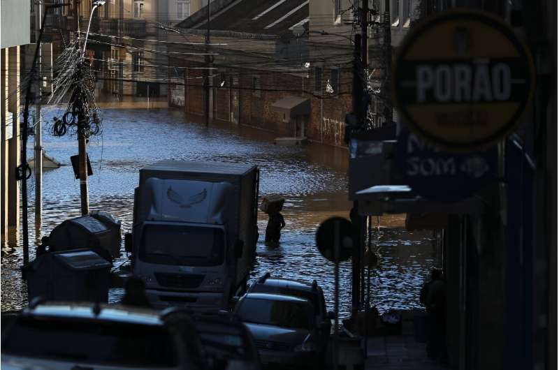 A man carries a package through a street in Porto Alegre, a main city in southern Brazil that has been devastated by flooding