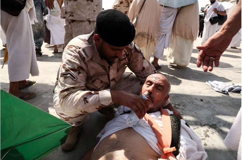 A man effected by the scorching heat is helped by a member of the Saudi security forces as Muslim pilgrims perform the symbolic 'stoning of the devil' ritual as part of the hajj pilgrimage in Mina