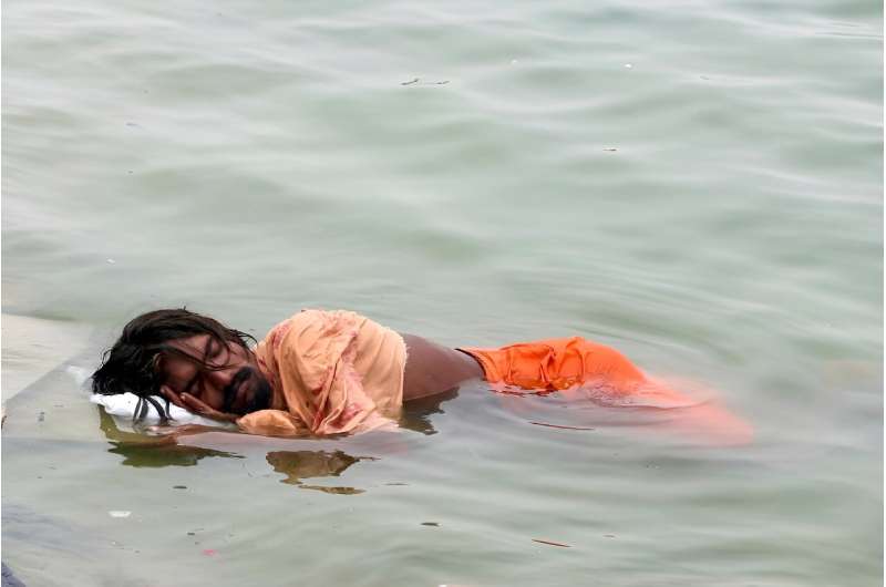A man in India sleeps in the River Ganges in Varanasi on June 18: much of northern India has been gripped by a brutal month-long heatwave