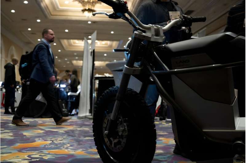 Seorang pria berjalan melewati e-bike di resor The Mirage selama Consumer Electronics Show (CES) di Las Vegas