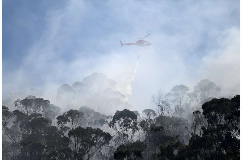 A military helicopter in Colombia dumps water on a forest fire burning outside Bogota on January 23, 2024