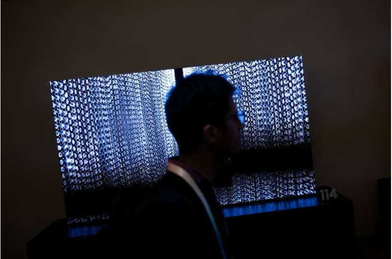 A person walks past TV screens at the Samsung First Look preview at the Caesars Palace resort, a pre-show for this weeks Consumer Electronics Show January 7, 2024, in Las Vegas, Nevada.