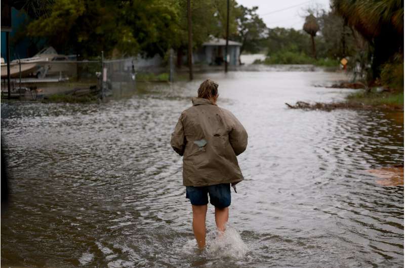 A person walks through a flooded street in Cedar Key, Florida on August 5, 2024