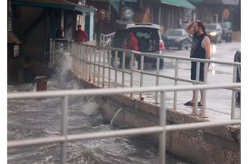 A rain-soaked man in Cedar Key, Florida observes waves kicked up by the winds of Tropical Storm Debby, which is strengthening as it moves through the Gulf of Mexico on August 04, 2024