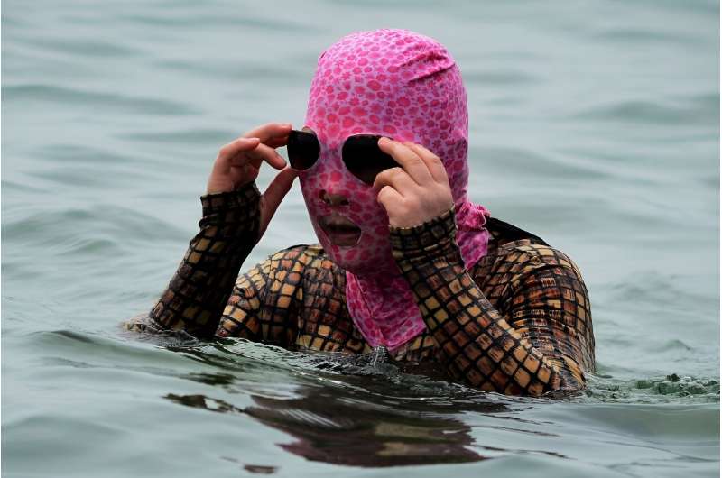 A swimmer tries to keep cool during a heatwave by swimming at a beach in Qingdao, in eastern China's Shandong province