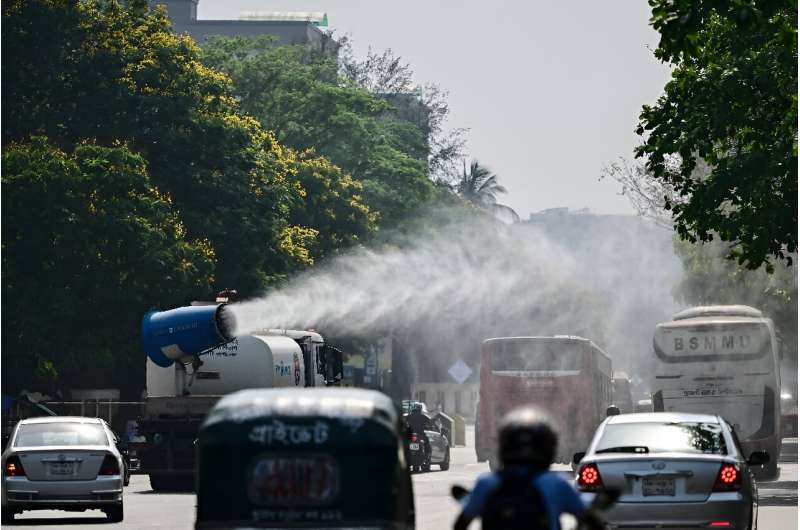 A vehicle of the Dhaka North City Corporation sprays water along a busy road to lower the temperature amidst a heatwave