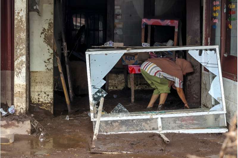 A woman cleans a home that was damaged in the floods in Rambatan Village, Tanah Datar Regency on Sumatra