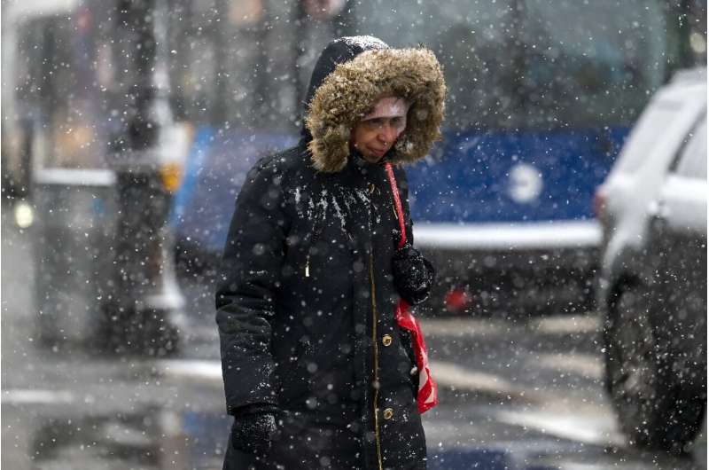 A woman walks as snow falls during a storm in New York City on January 19, 2024, but several parts of the country were getting pummelled by blizzard conditions